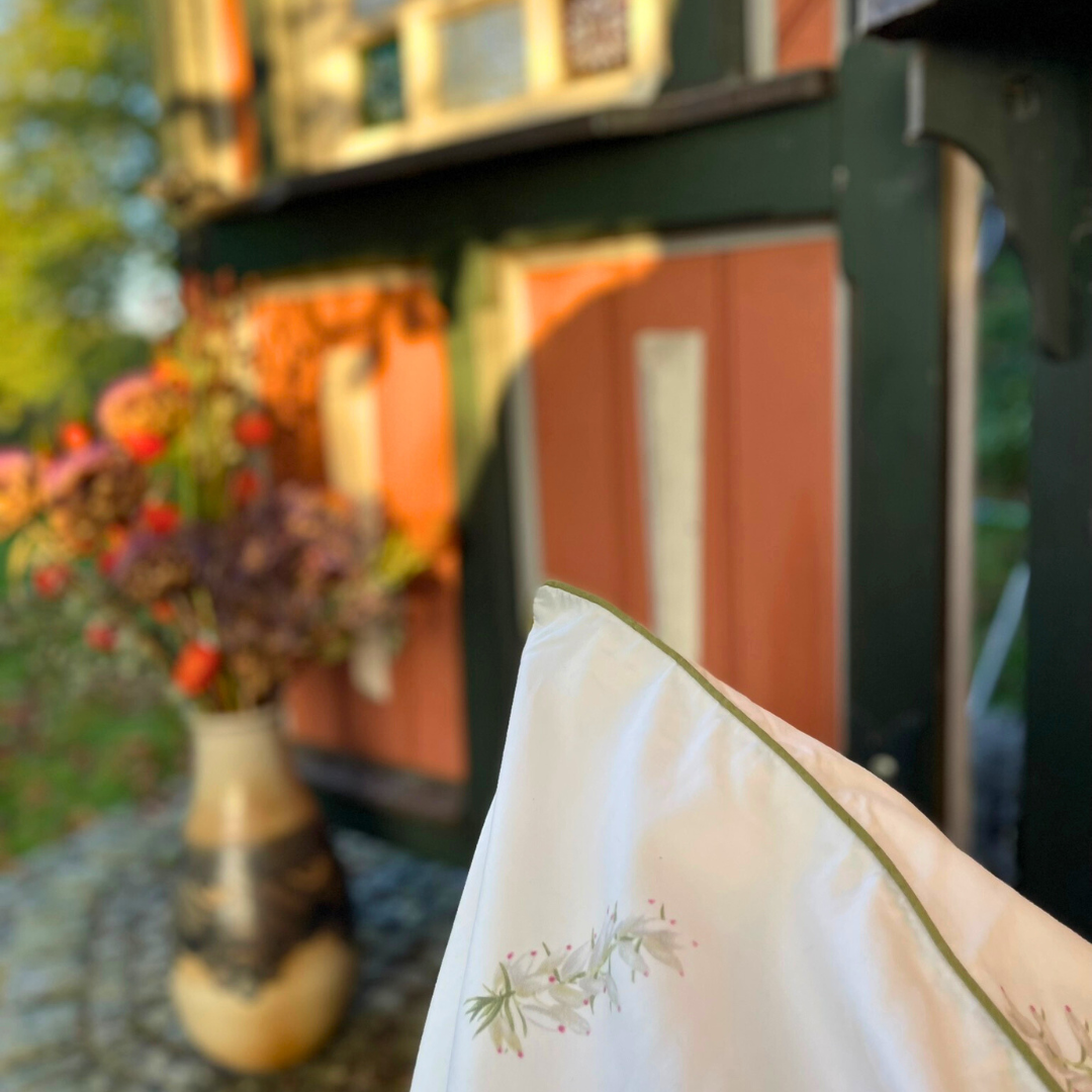 Detailansicht des floralen Naturmusters vom Kissenbezug Erika aus feinem Mako-Satin