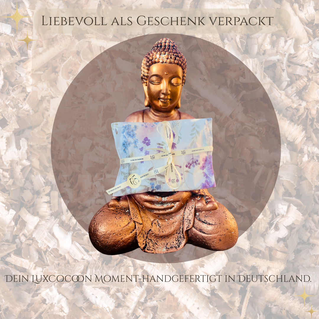 LuxCocoon Mini-Zirbenkissen als liebevoll verpacktes Geschenk, präsentiert von einer Buddhafigur – handgefertigt in Deutschland.