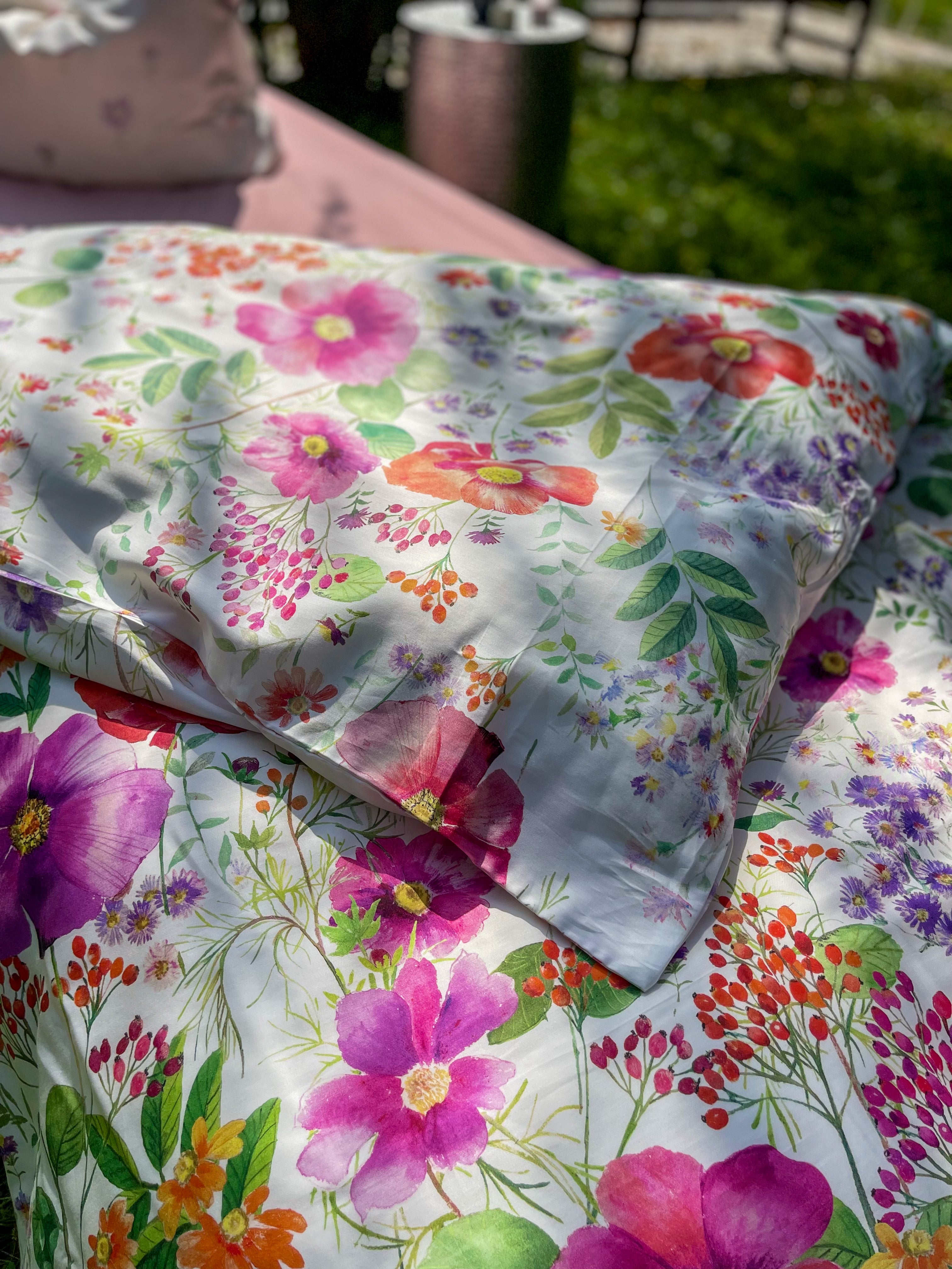 Detailaufnahme eines floralen Mako-Satin Kissenbezugs – fein gewebte Baumwolle mit seidig glattem Griff