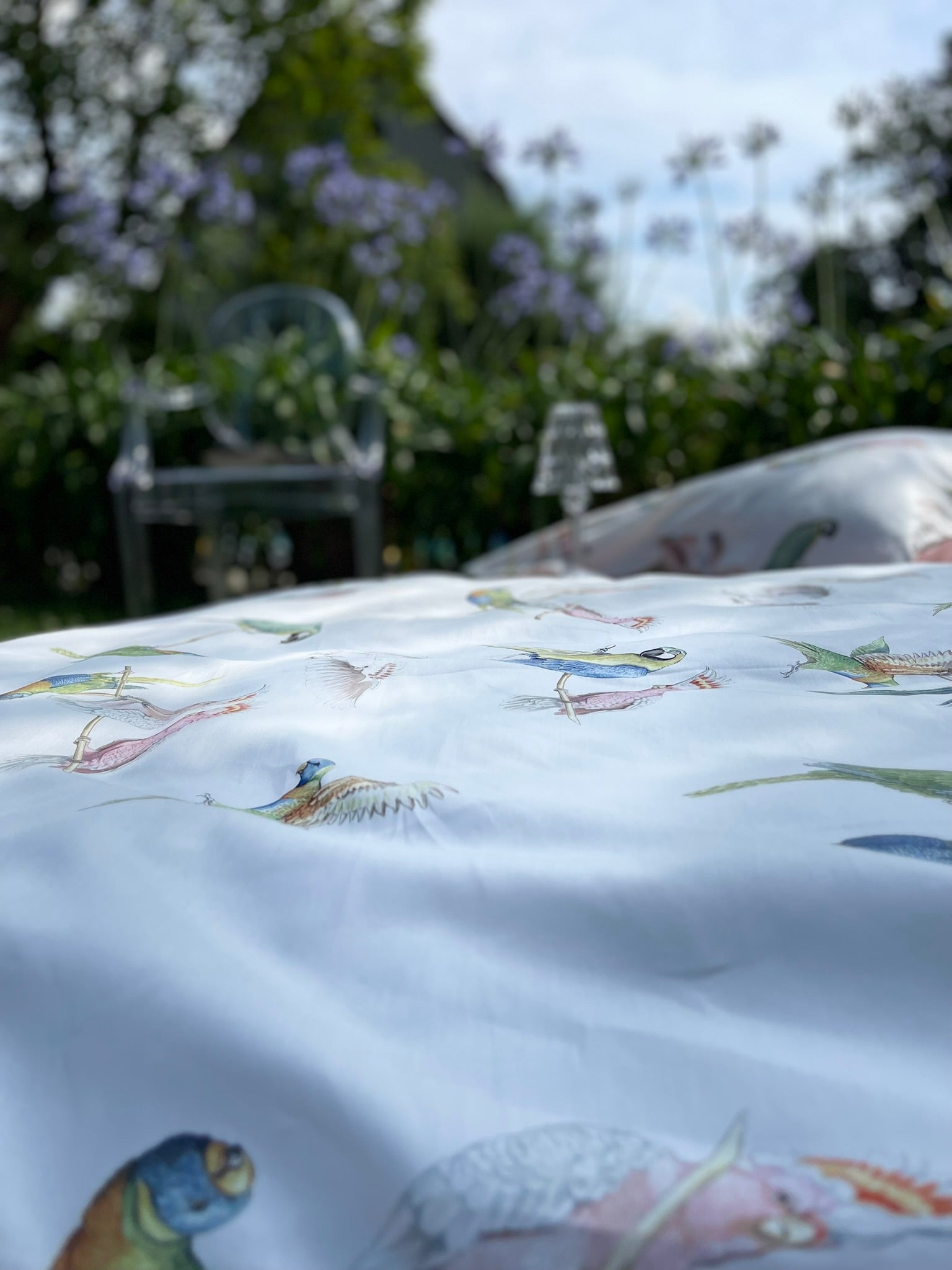 Flatlay der Bettwäsche Exotische Vögel – luxuriöser Mako Satin mit tropischem Muster.