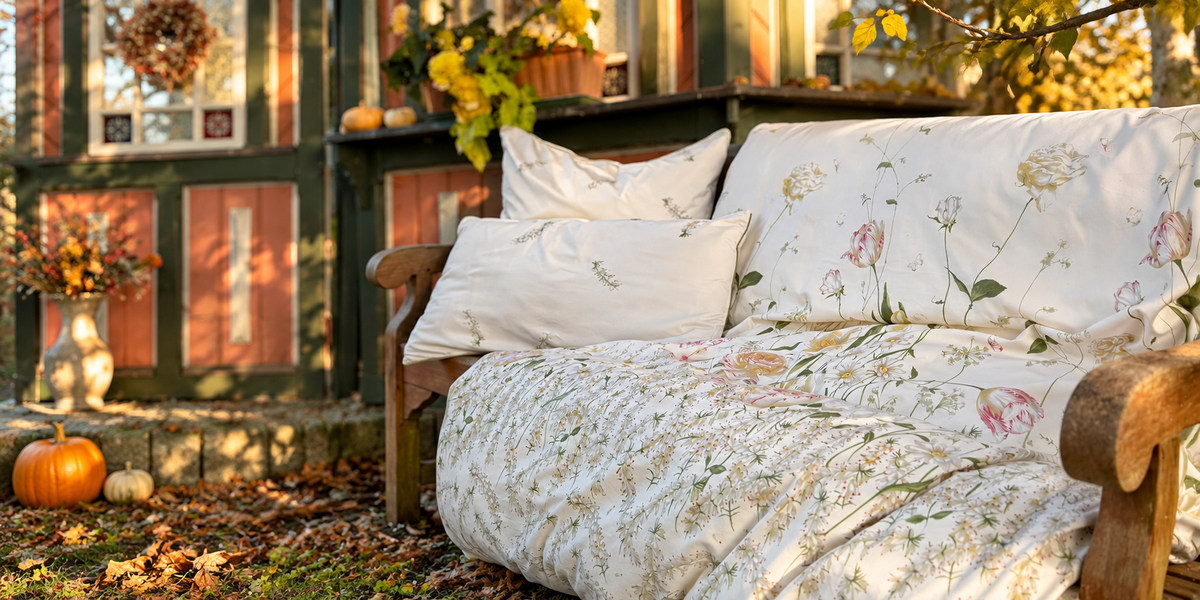 Florale Mako-Satin-Bettwäsche von LuxCocoon auf einer Holzbank im warmen Herbstlicht